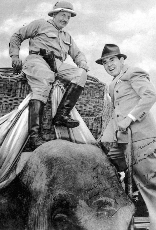 Frank Buck astride elephant with John Ringling North on the right.